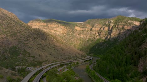 glenwood springs aerial drone summer glenwood canyon scenic drive i70 west east traffic cars colorado river traffic sun cliffside afternoon sunset dark rain thunderstorm cloudy forward upward motion