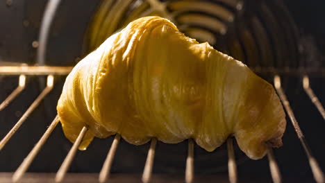 homemade croissant being bake in oven with melted butter dripping from bread