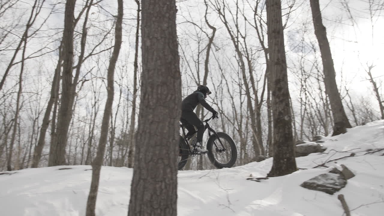 Cyclist climbing a hill in the winter on fat bike