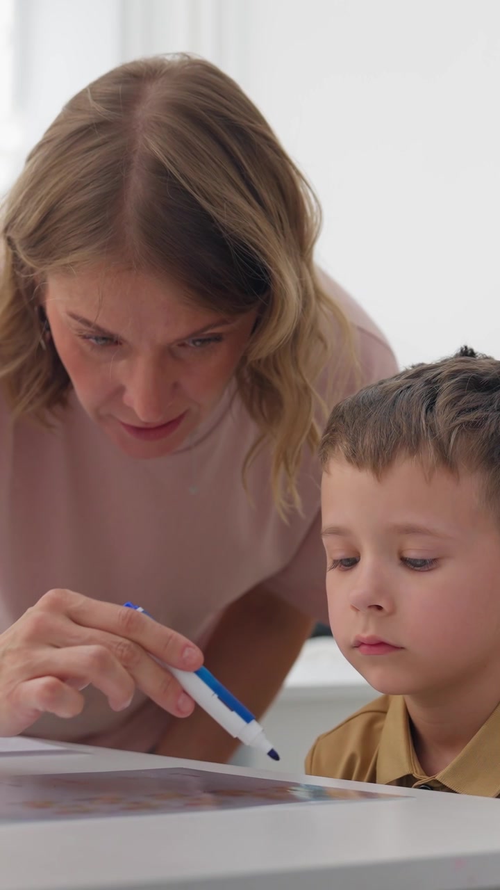 Insegnante che aiuta un bambino con un'attività didattica in classe