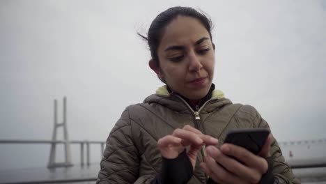 Mujer-Hindú-Pensativa-Usando-Un-Teléfono-Inteligente-Al-Aire-Libre