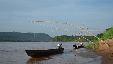 Botes-Largos-Amarrados-Y-Rebotando-En-La-Orilla-Del-Río-Mekong-En-El-Lado-De-Tailandia,-En-Ubon-Ratchathani