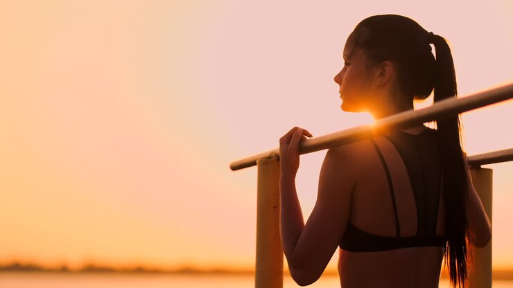 The theme women sports and health. Beautiful caucasian woman with curly long hair posing on outdoor sports ground holding hor. The theme woman sports and health