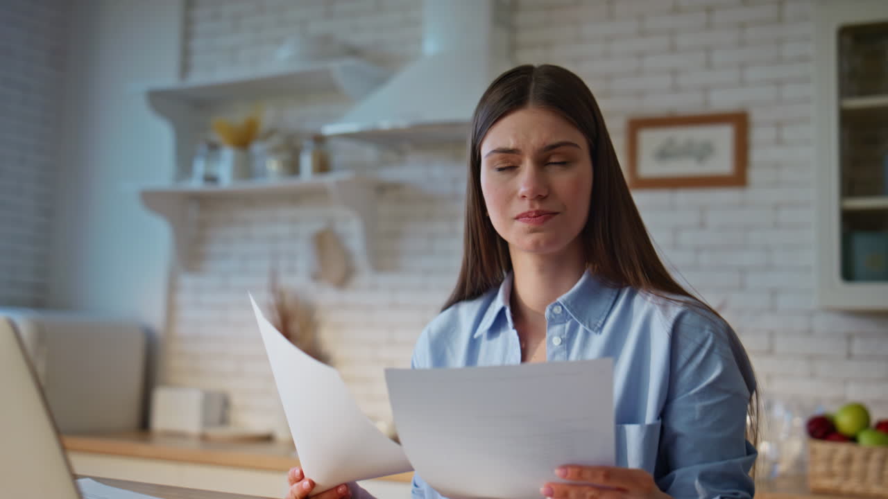 Woman accountant reviewing documents managing paperwork with laptop closeup