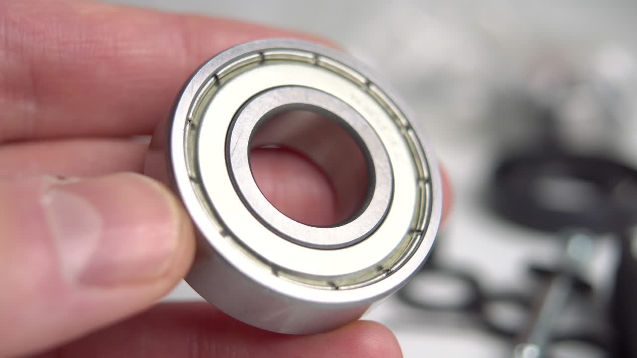 손에 있는 산업용 베어링. 기계 부품. 배경에 있는 도구. 매크로