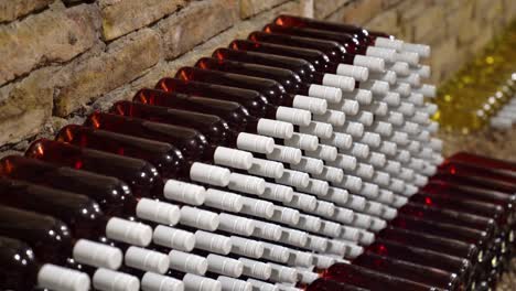 Bottles-of-rose-wine-displayed-in-bricked-walls-vintage-cellar-Closeup-slow-shot