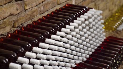 botellas de vino rosado exhibidas en paredes de ladrillo bodega de cosecha primer plano disparo lento