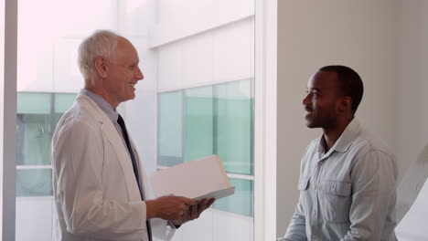Doctor-Meets-With-Male-Patient-In-Exam-Room-Shot-On-R3D