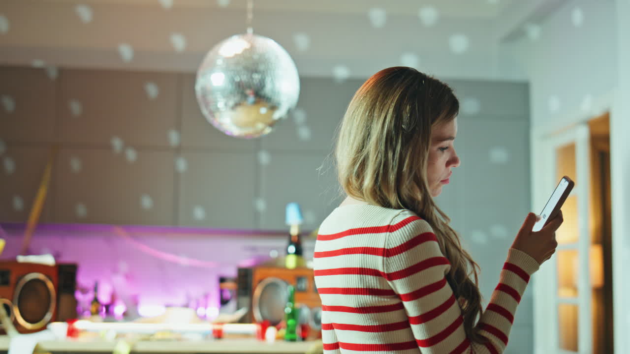 Sad party girl scrolling smartphone under disco ball close up. Woman reading