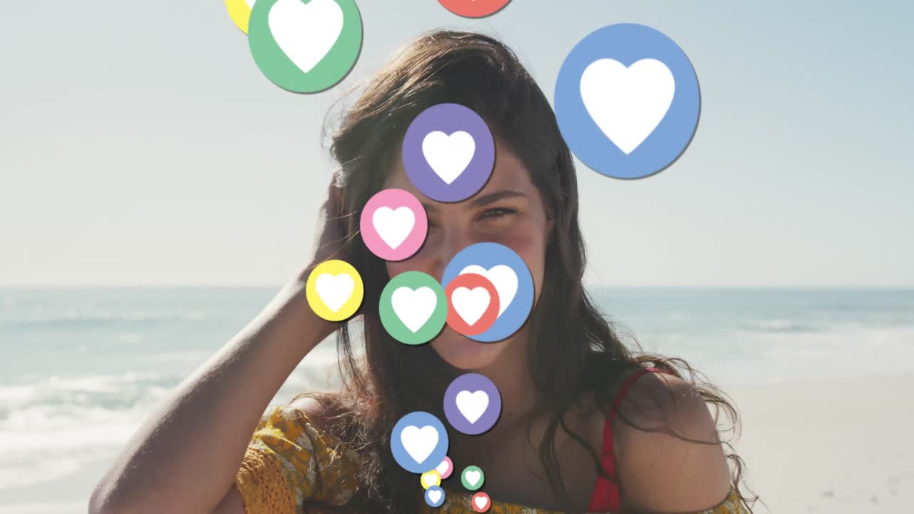 animación de iconos digitales de corazón sobre el retrato de una mujer sonriente en la playa