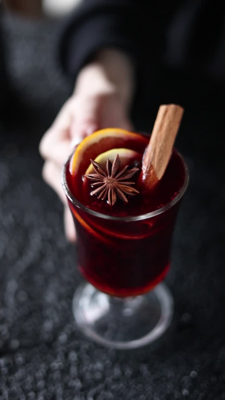 Persona che tiene un bicchiere di vin brulé