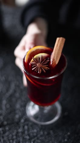 person holding a glass of mulled wine