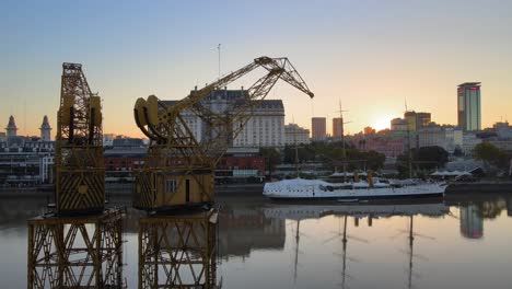 Aerial-orbiting-view-of-cranes-at-Puerto-Madero,-Buenos-Aires,-at-dusk