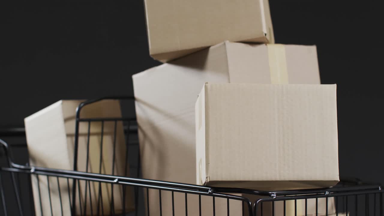 Video of shopping trolley and boxes with copy space over grey background