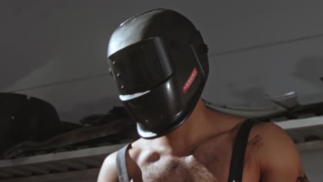 welder sexy mechanic dancing naked doing sparks on a car metal body, in a mask with big muscular biceps, 50 fps ready for slow motion