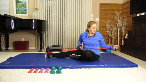 mature woman exercising on mat pulling on stretch bands, static locked off tripod