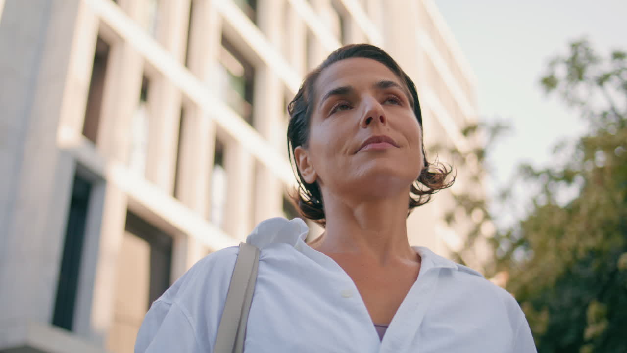 retrato mujer segura posando en la fachada del edificio de negocios. dama mirando cámara