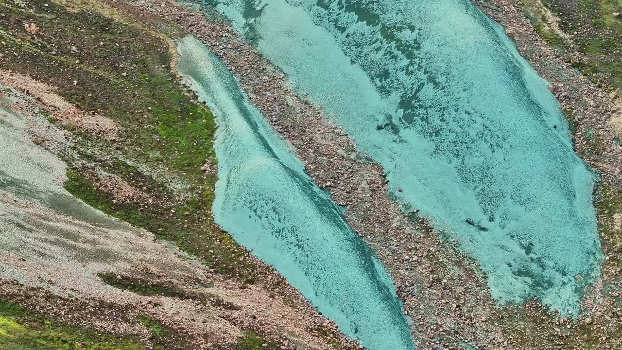 movimiento aéreo de arriba a abajo revelando la segunda roca más pequeña de grænihryggur, la roca verde, en landmannalaugar, islandia, haciendo hincapié en los tonos medios de naranja y verde