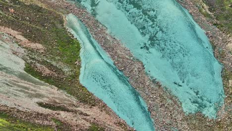 aerial drone top to bottom movement revealing the second, smaller rock of grænihryggur, the green rock, in landmannalaugar, iceland, emphasizing the medium tones of orange and green