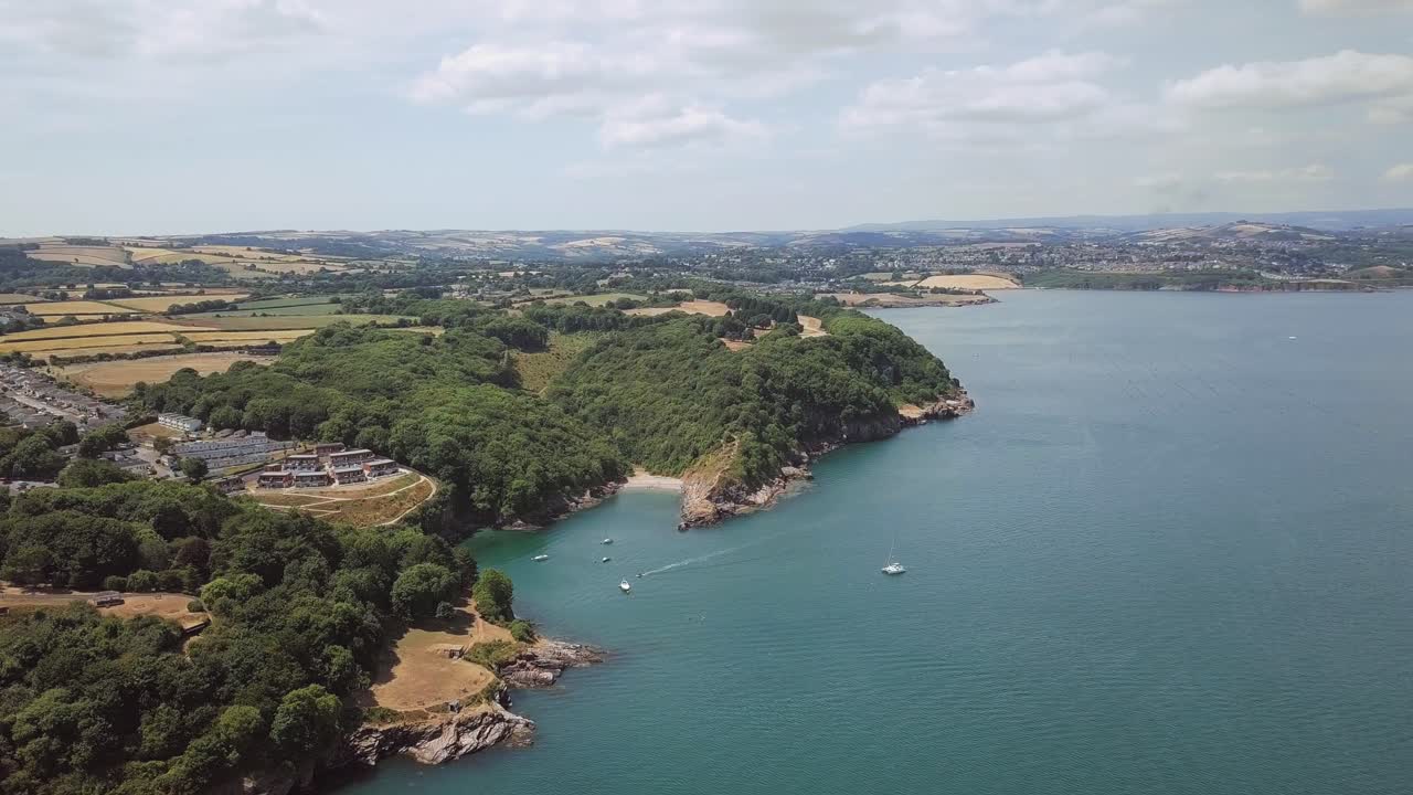 Aerial view of coastline with trees, sea, and town
