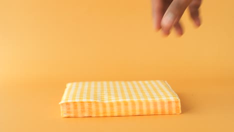 hand reaching for a yellow and white checkered napkin