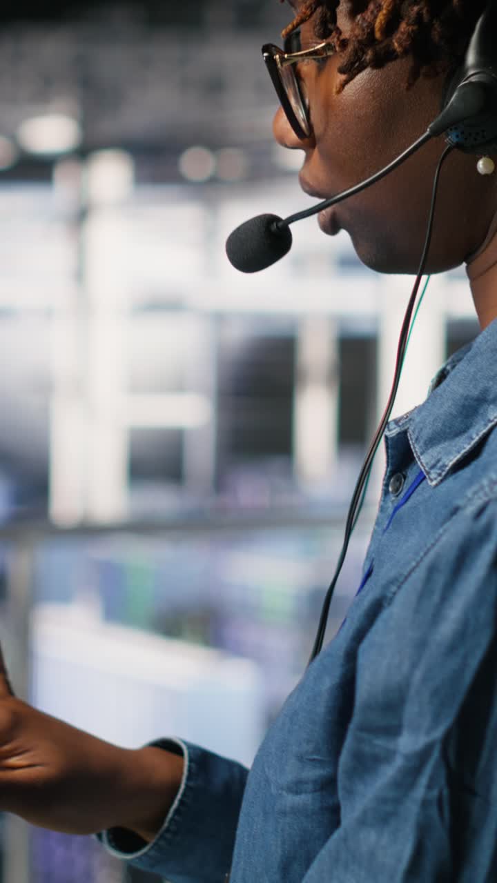 Vertical video Data center worker speaks in headset mic, overseeing maintenance on AI rigs