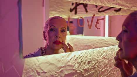 Glamour senior looking mirror touching face closeup. Cool pensioner reflection