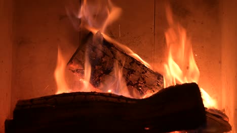 cerca del fuego de la chimenea quemando un trozo de madera para calentar la casa durante la crisis de la guerra