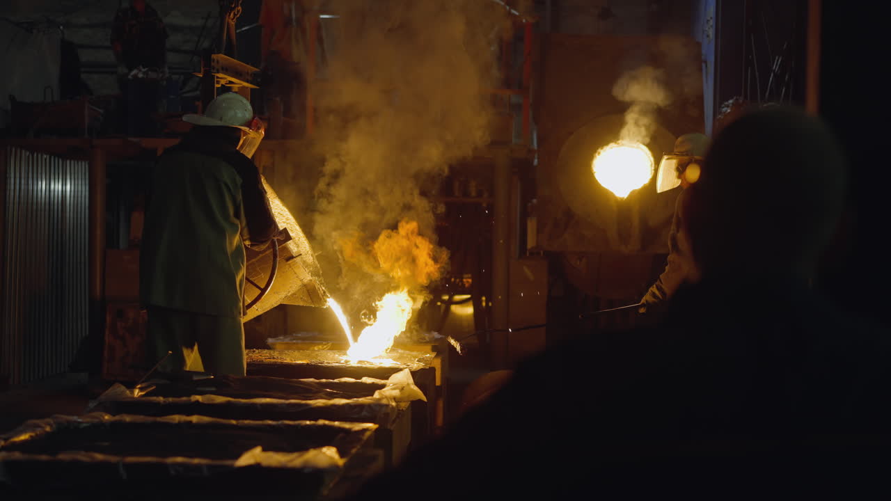 Foundry scene with workers and a fiery furnace erupting with sparks