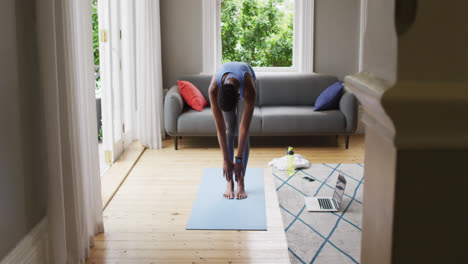 African-american-woman-performing-stretching-exercise-at-home