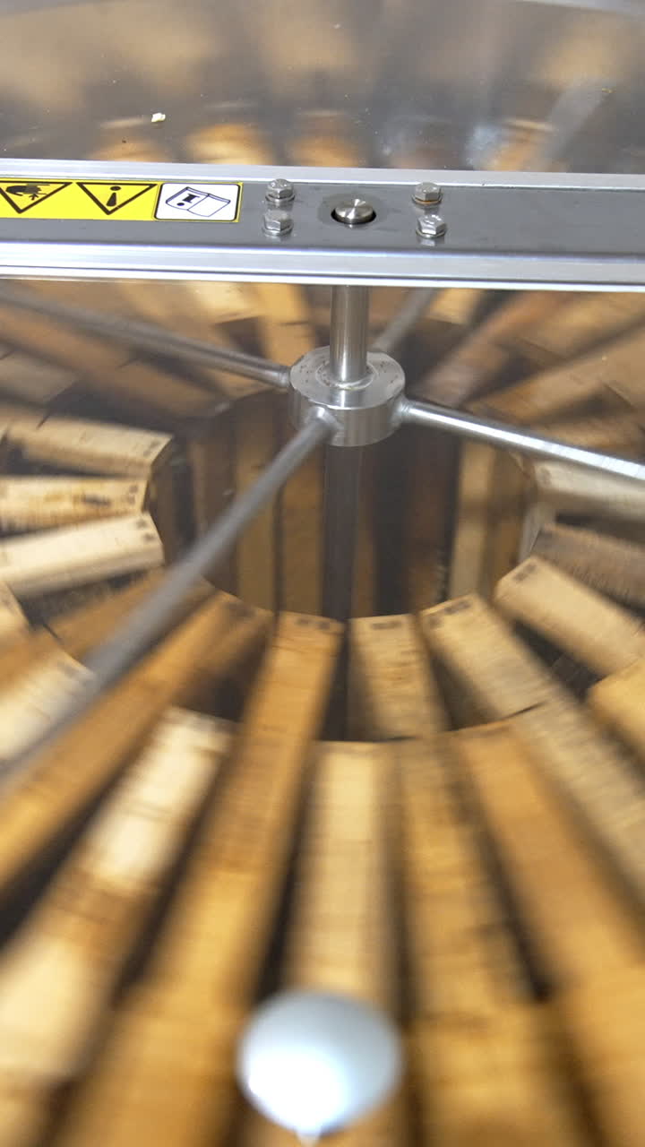 Centrifuge device rotating to pump the honey out of honeycombs. Special apiary equipment for harvesting honey. Vertical video