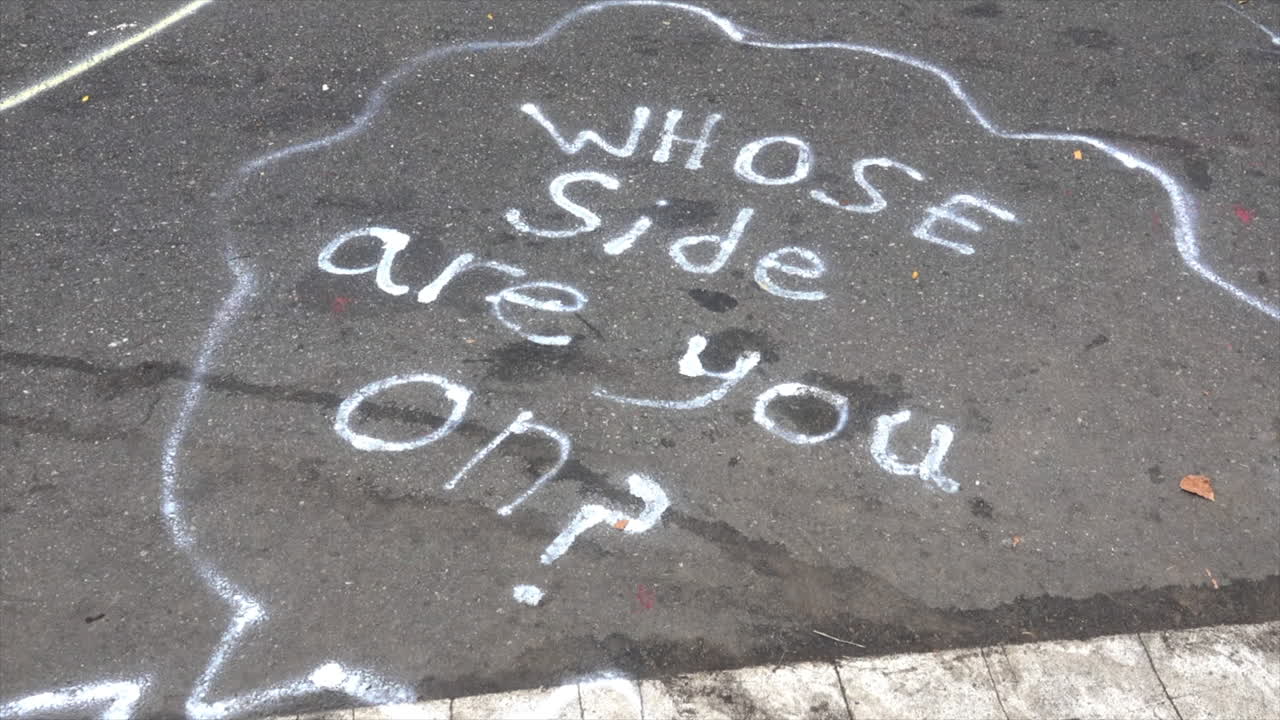 Street graffiti asks, "Whose side are you on?" at homeless rights protest