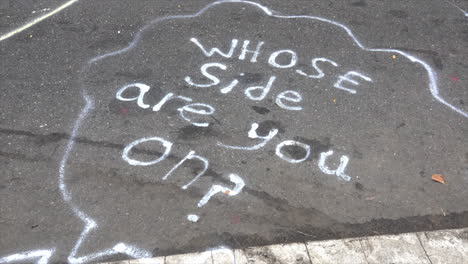 street graffiti asks, "whose side are you on?" at homeless rights protest