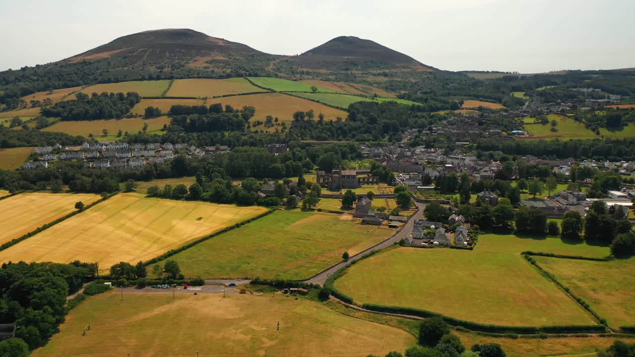 Aerial pullback shot of small Scottish countryside town of Melrose