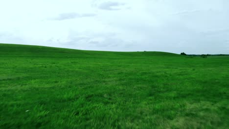 aerial footage over green hill on village landscape