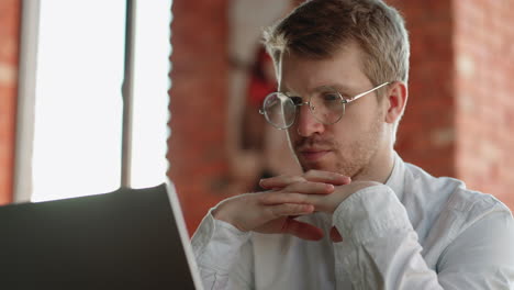 hombre pensativo está leyendo noticias en internet mirando la pantalla de su computadora portátil en un café retrato de un hombre pensante