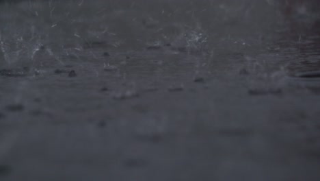 raindrops splashing in a puddle during heavy rain