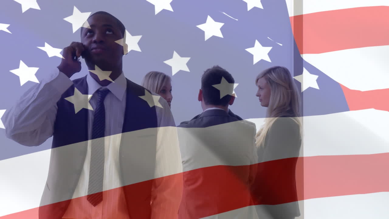 Animation of American flag waving over businessman talking on the smartphone his colleagues