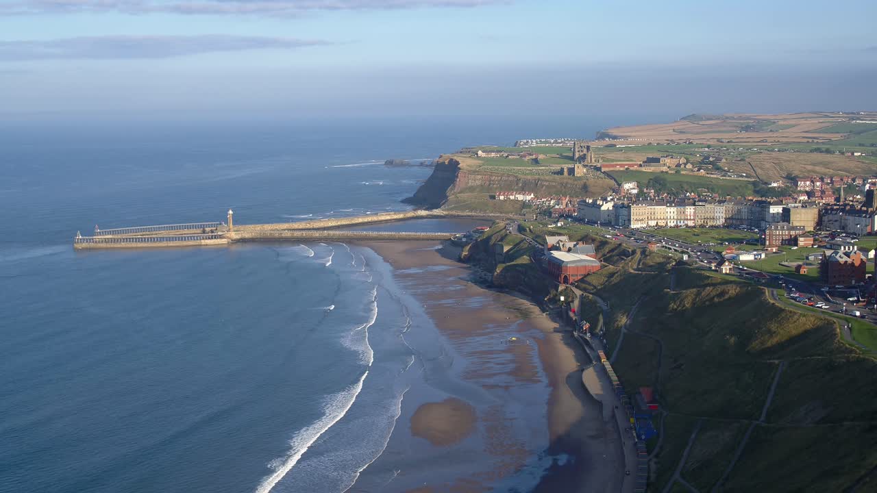 North York Moors, Whitby langsom luftnedstigning over den vestlige klippe med udsigt mod Whitby mole og kloster i solskin. Slutningen af 2021. DJI Inspire 2 Prores