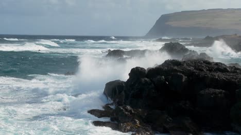 big waves roll into a tropical island and crash onto the shore