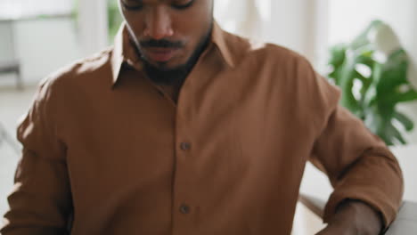 Focused-guy-looking-smartphone-apartment-closeup.-Dreadlocks-man-reading-message