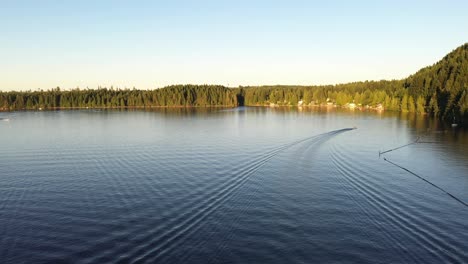 Boat-going-back-to-shore-after-a-long-day-on-the-water,-Comox-lake,-British-Columbia