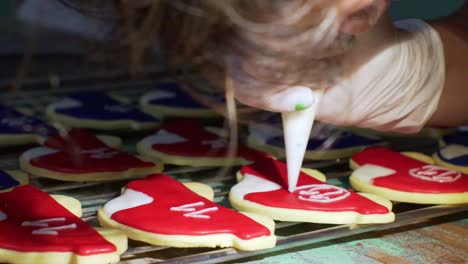 Frau-Dekoriert-Hausgemachte-Kekse-In-Fahrzeugform-Mit-Zuckerguss-Mit-Einem-Spritzbeutel