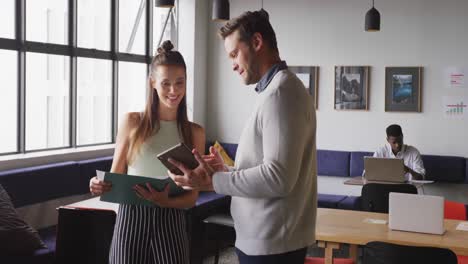 Happy-caucasian-business-people-discussing-work-during-meeting-at-office