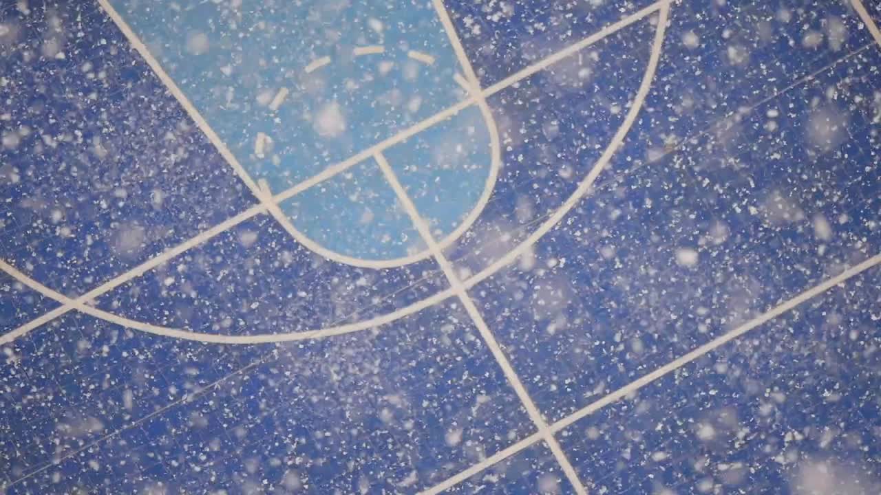 Snow falling on a blue basketball court