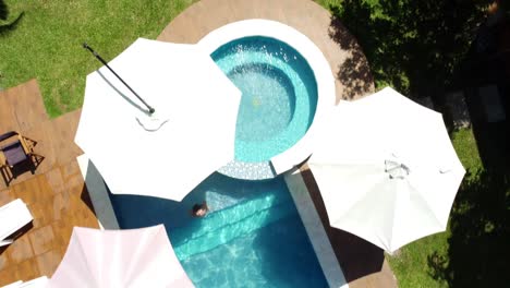 top down aerial view of people swimming in the pool