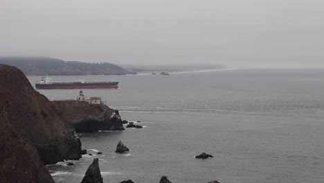 point bonita lighthouse in the san francisco bay off the coast of the golden gate on a cloudy, hazy, foggy day