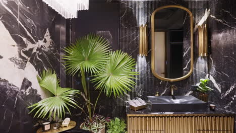 elegant bathroom interior with fan palm plant, decorative wall mirror, and marble-effect wall panels