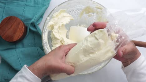 making a dessert called red raspberry tea cake made with fresh berries and vanilla buttercream frosting. great for tea parties. putting the vanilla buttercream frosting into a plastic piping bag