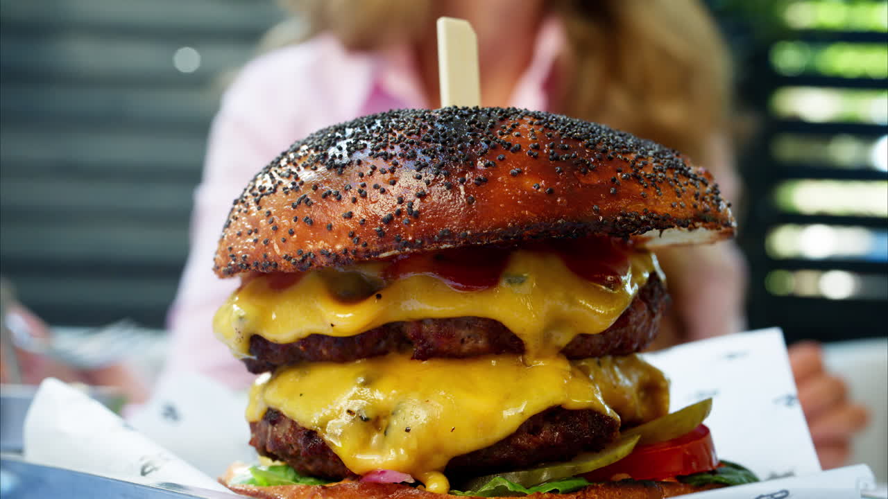 Close up of a big hamburger on a table at a restaurant